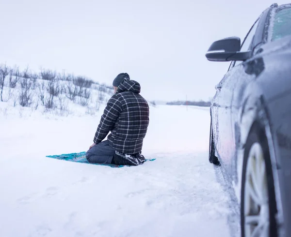 Muslim traveler praying in winter mountain — Stock Photo, Image