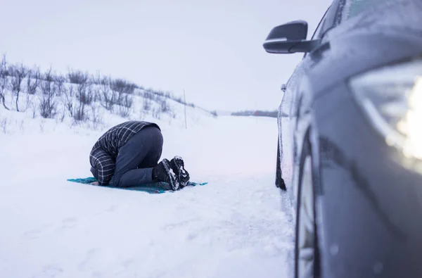 Muslim traveler praying in winter mountain — Stock Photo, Image