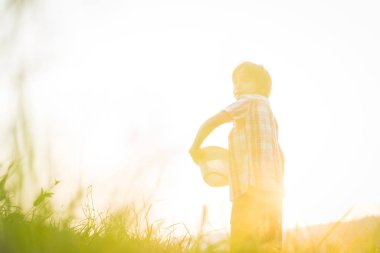 Rahat çocuk çayırda günbatımının tadını çıkarıyor.