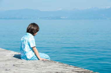 Genç çocuk sahilde eğleniyor.