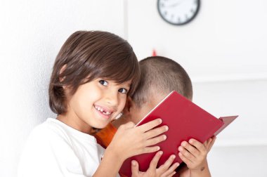 Kardeşler kitap okuyor. Yakın çekim.