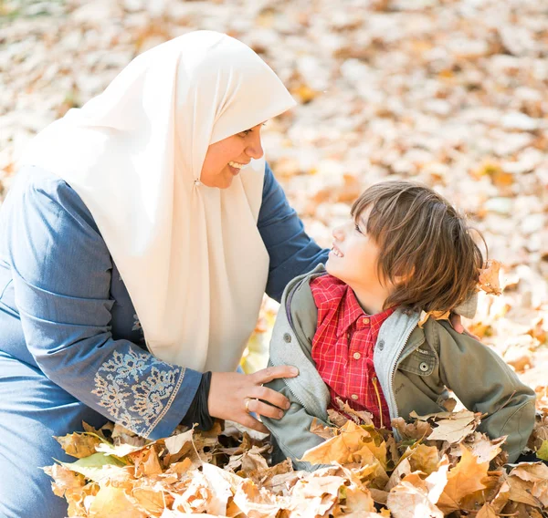 Sonbahar Yapraklarında Küçük Oğlu Olan Arap Bir Anne — Stok fotoğraf