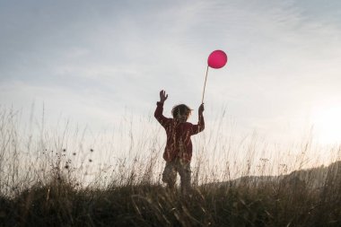 Çimenlerde balonu olan çocuk
