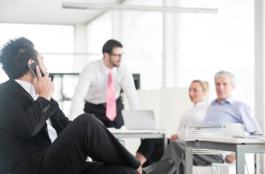 İş adamları ve yöneticiler laptop kullanarak toplantı yapıyorlar.