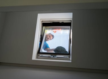 Man on loft window cleaning clipart