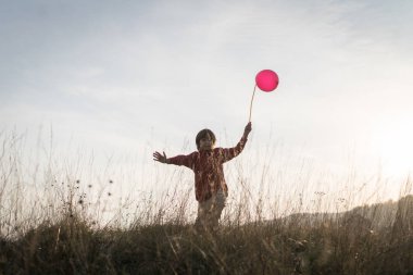 Çimenlerde balonu olan çocuk