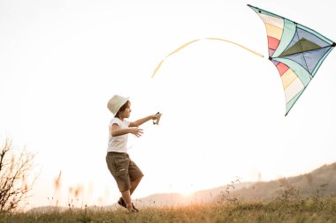 Çayır üzerinde uçurtması olan küçük çocuk