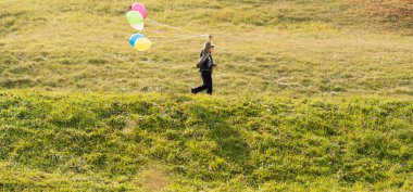 Balonlu çayırdaki küçük şirin çocuk.