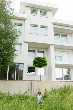 Güzel modern evin arka bahçesinde bir çocuk.