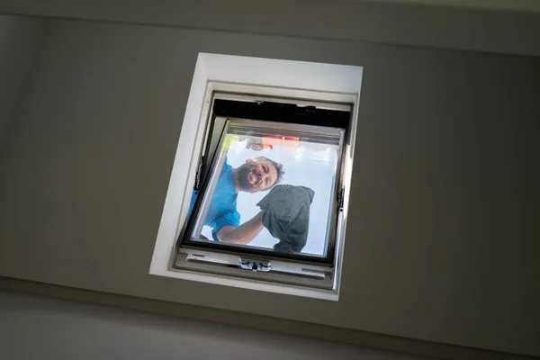 Mann Auf Dachboden Beim Fensterputzen — Stockfoto