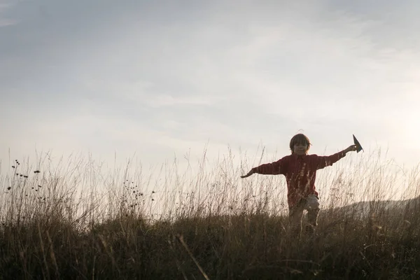 Çimlerde Kağıt Uçakla Gezen Mutlu Küçük Çocuk — Stok fotoğraf