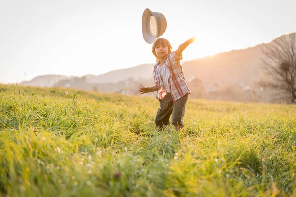 草の牧草地で幸せな小さな子供 — ストック写真