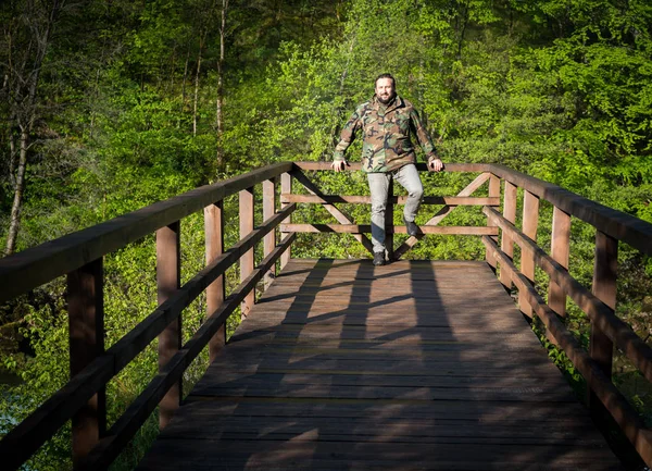 长大成人站在森林的桥上 — 图库照片