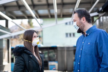 Sokakta virüs kirliliğine karşı maskeli bir çift