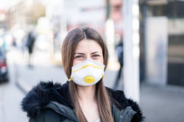 Kirliliğe karşı maskeli genç bir kadın
