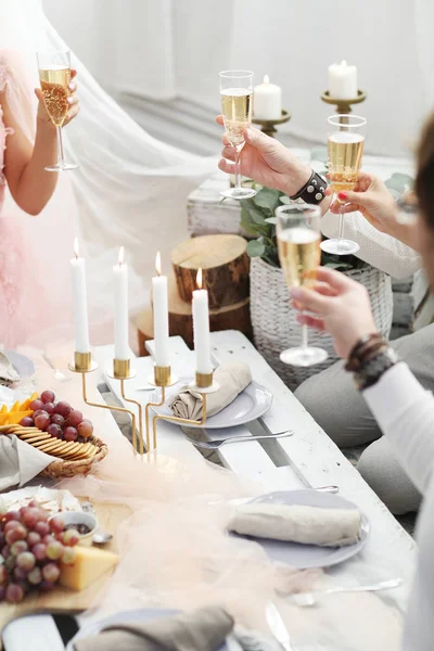 people clanging glasses of champagne together at wedding party, closeup