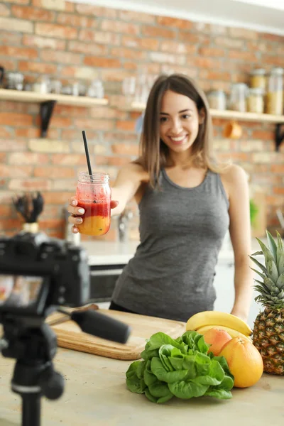 smiling female food blogger with jar of smoothie at kitchen, healthy food