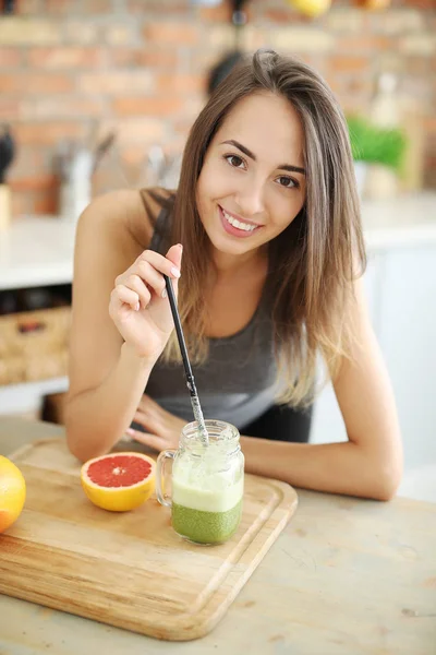 smiling female food blogger with jar of smoothie at kitchen, healthy food