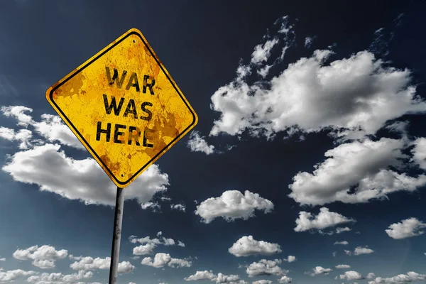 戦争はここにテキストを黄色の色あせた道路標識と積雲の雲と濃い青空の背景 — ストック写真