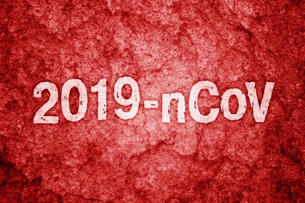 2019-nCoV kirjoitus maalattu punaiselle karkealle seinälle — kuvapankkivalokuva