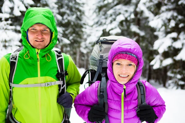Pár boldog túrázók, túrázás, téli erdőben — Stock Fotó