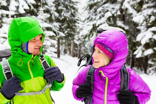 Pareja excursionistas felices trekking en bosques de invierno —  Fotos de Stock