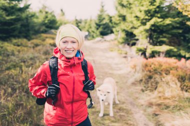Mutlu kadın ile köpek sonbahar ormanda yürüyüş hiking