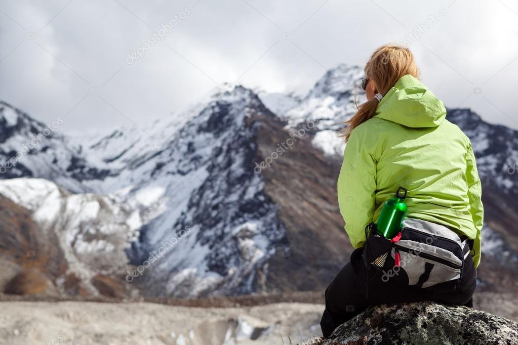 Woman hiker relaxing on rocks in Himalaya Mountains, Nepal