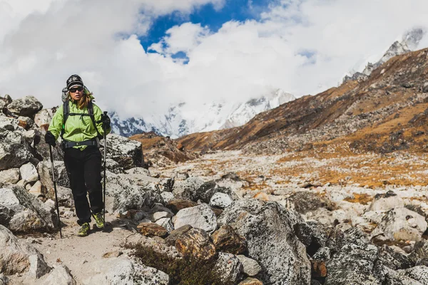 Senderismo femenino en las montañas del Himalaya en el sendero rocoso — Foto de Stock