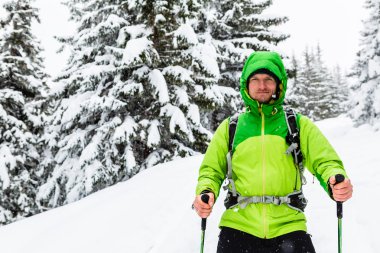 Kış fiyatı beyaz karlı ormanda sopa hiking ile yürüyüş ve