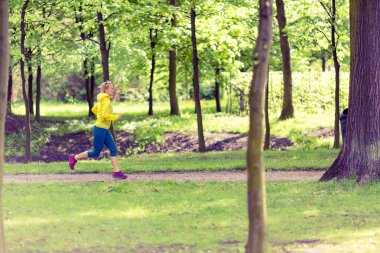 Yeşil Yaz park ve ormanda koşu çalışan kadın runner