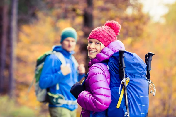 男と女の幸せなカップル ハイカーが秋の森を歩いて — ストック写真