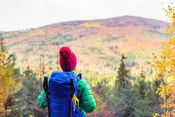 Mujer senderista con mochila mirando inspiradora montura de otoño — Foto de Stock