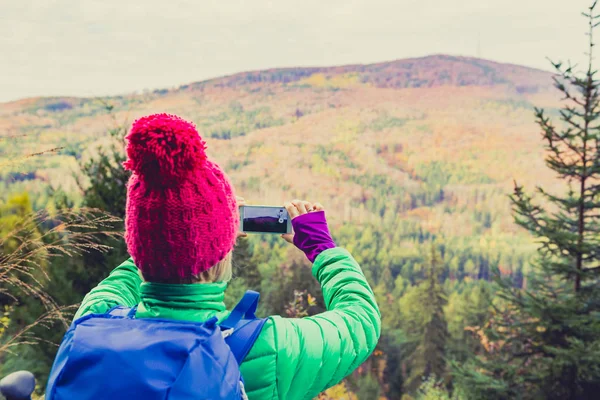 Wandelen van vrouw met rugzak nemen van foto met smartphone — Stockfoto