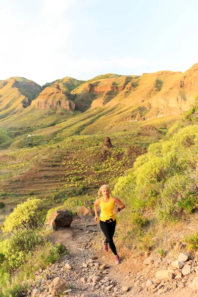Jovem mulher correndo em trilha de montanha — Fotografia de Stock