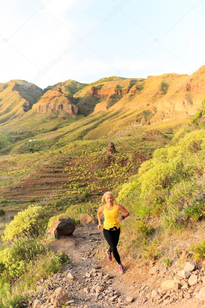 Young woman running on mountain trail