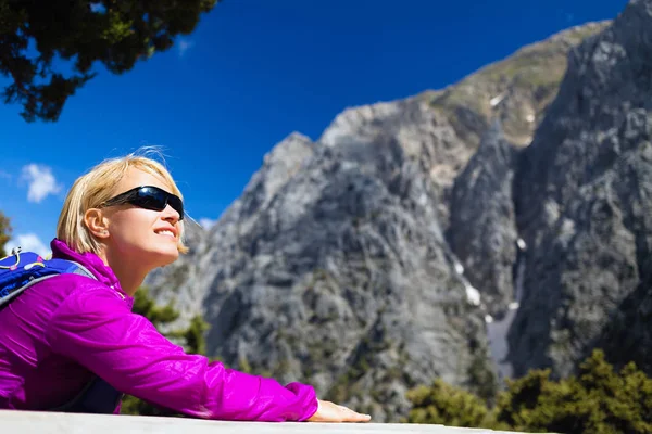 Leende kvinna avkopplande och vilar i vackra berg — Stockfoto