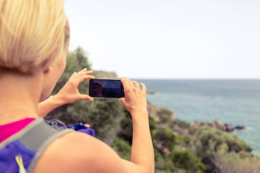 Fotoğrafta smartphone ile sırt çantası ile çalışan kadın