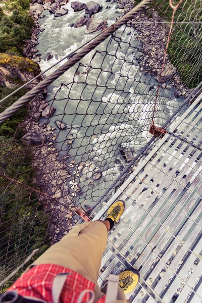 Backpacker atravessando ponte suspensa e olhando para baixo em Himala — Fotografia de Stock