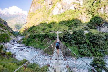 Kadın backpacker geçiş asma köprü Himalayalar Nepal