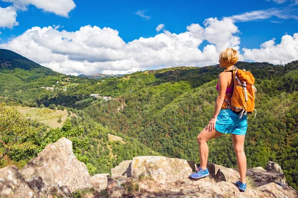 Пешеходная женщина смотрит на вдохновляющие горы пейзаж — стоковое фото