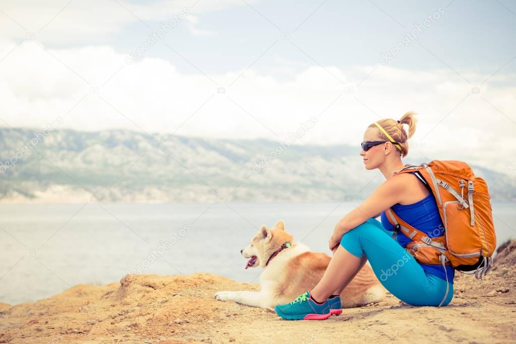 Woman hiking walking with dog on seaside trail