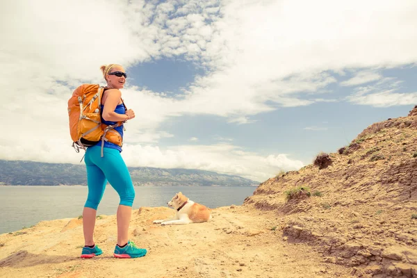 Kadın ile köpek deniz manzara üzerinde yürüme hiking — Stok fotoğraf