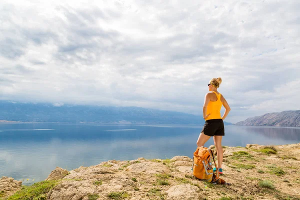 Woman hiker with backpack, hiking at seaside and mountains — Stock Photo, Image