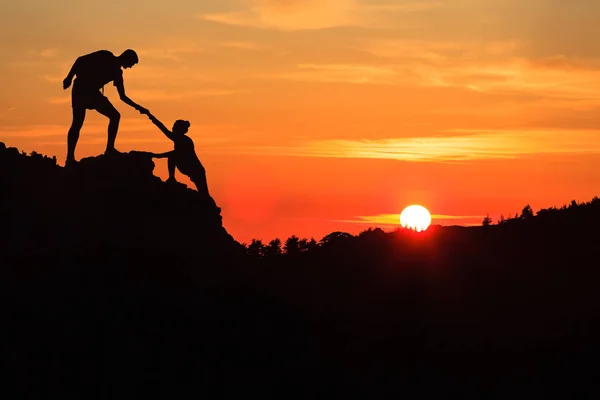 Pareja de trabajo en equipo ayudando a la confianza de la mano en montañas inspiradoras —  Fotos de Stock