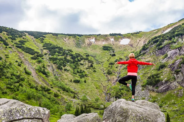 Mulher meditando em pose de ioga na frente do lago da montanha — Fotografia de Stock