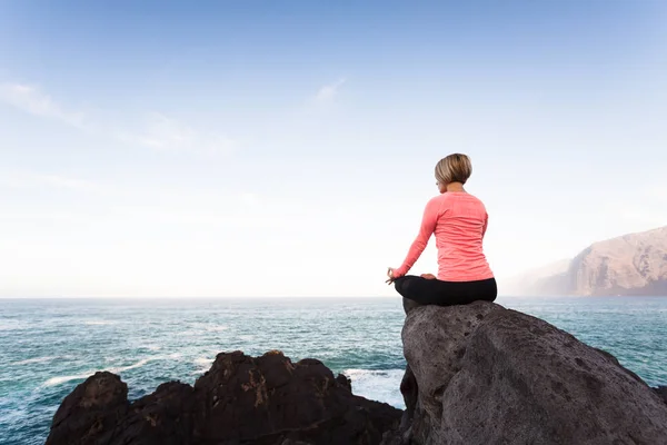 Ragazza di yoga meditare e rilassarsi in posa yoga, vista sull'oceano — Foto Stock