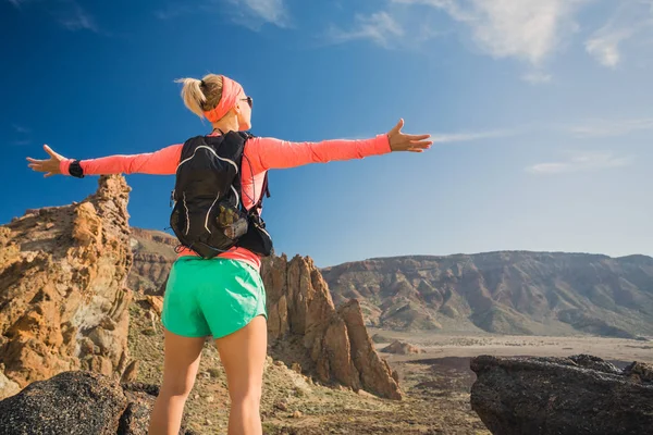 Kadın hiker uzanmış kollarıyla zevk dağlar — Stok fotoğraf