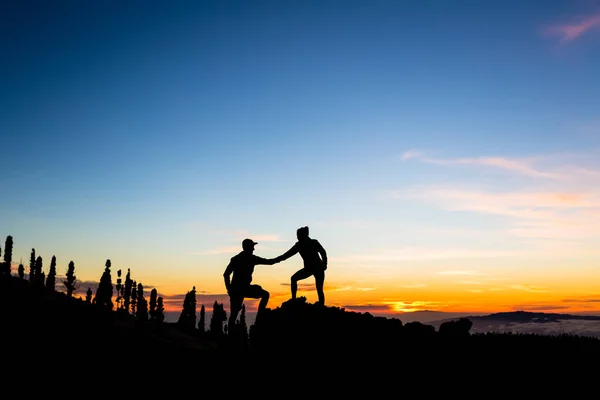 Teamwork paar klimmen met de helpende hand — Stockfoto