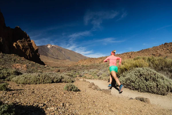 Trilha correndo mulher nas montanhas no dia ensolarado — Fotografia de Stock